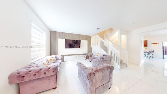 living area featuring baseboards, stairs, and visible vents