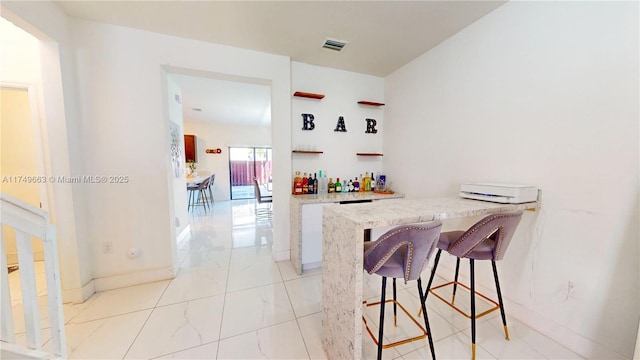 bar featuring a dry bar, visible vents, and baseboards