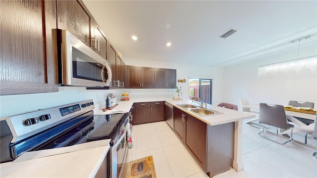 kitchen with dark brown cabinetry, visible vents, stainless steel appliances, light countertops, and a sink