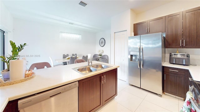 kitchen with stainless steel appliances, light countertops, a sink, and visible vents