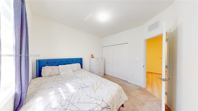 carpeted bedroom with a closet and visible vents