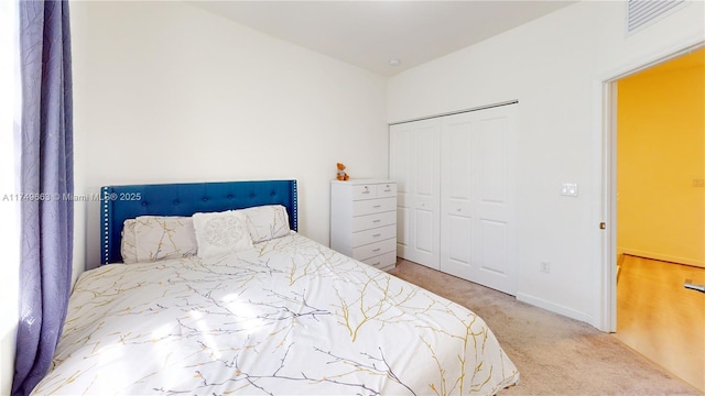 carpeted bedroom with a closet and baseboards