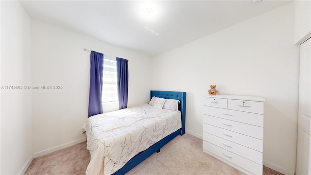 bedroom featuring light carpet and baseboards