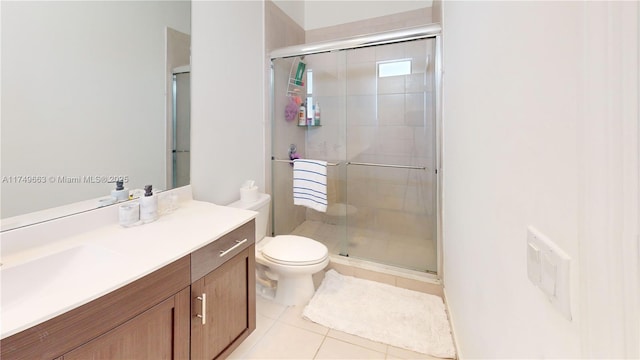 full bathroom featuring tile patterned flooring, a shower stall, vanity, and toilet