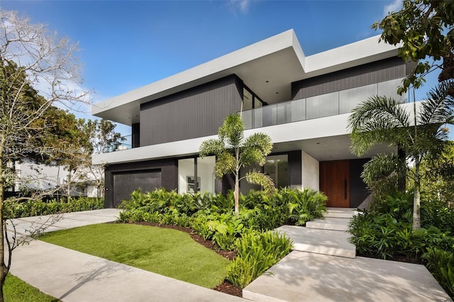 contemporary home featuring a garage, a front yard, and driveway