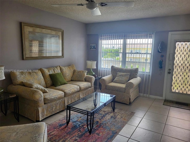 living area featuring light tile patterned flooring, ceiling fan, and a textured ceiling