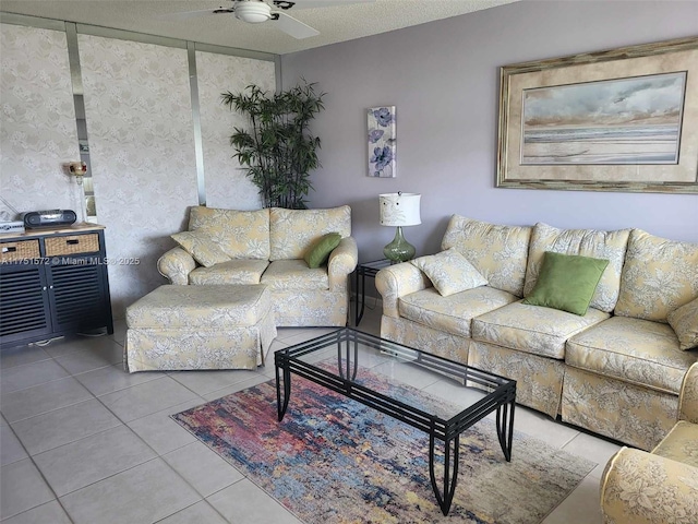 living room featuring ceiling fan, light tile patterned floors, and a textured ceiling