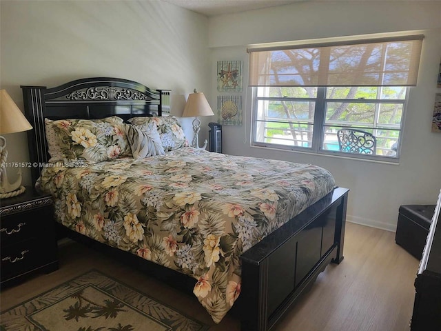 bedroom featuring baseboards and light wood-style floors