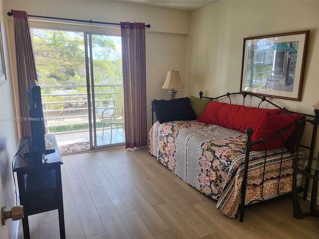 bedroom with access to exterior and light wood-style floors