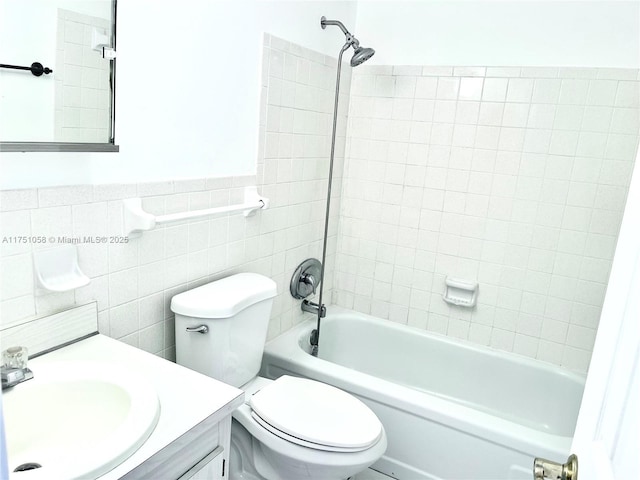 full bath featuring shower / tub combination, toilet, a wainscoted wall, vanity, and tile walls