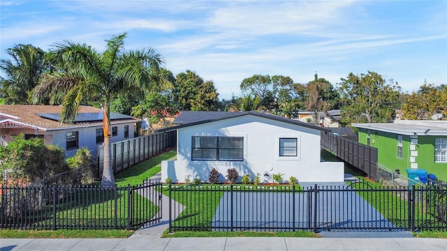 view of front of house with a front lawn, a fenced front yard, and stucco siding