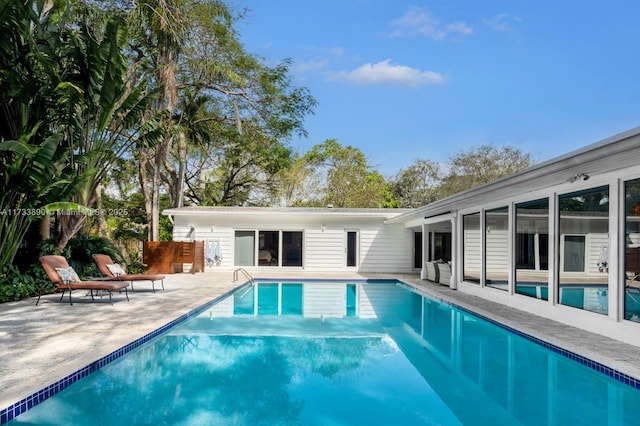 outdoor pool with a patio and fence