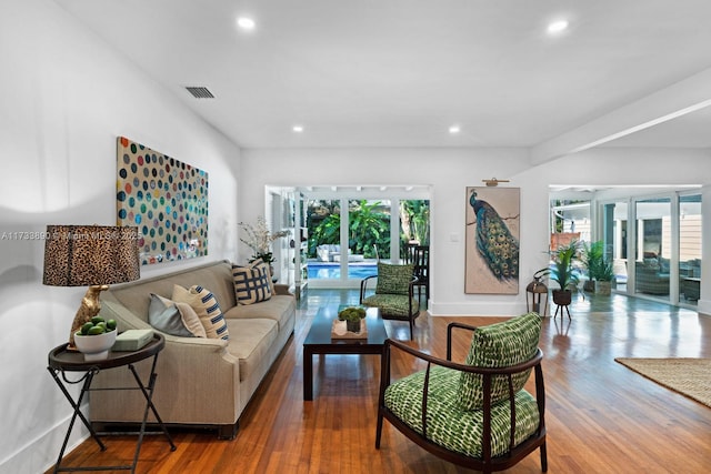 living area with a wealth of natural light, visible vents, recessed lighting, and wood finished floors