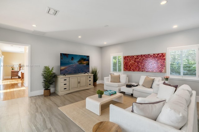 living area featuring visible vents, a wealth of natural light, and recessed lighting