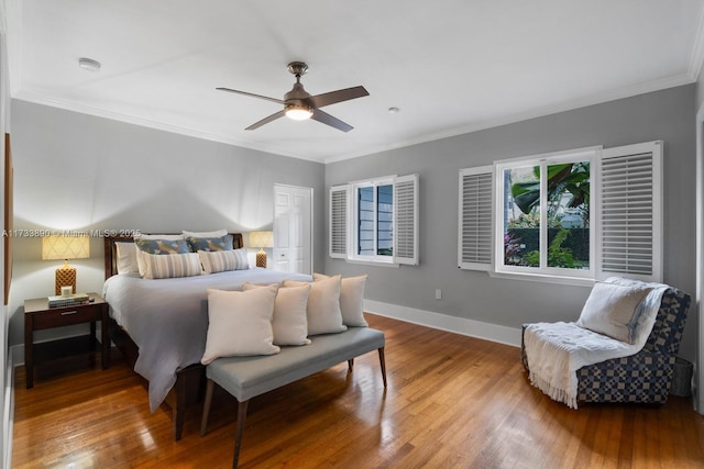 bedroom featuring crown molding, baseboards, and wood finished floors