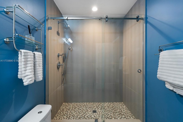 bathroom featuring a stall shower and toilet