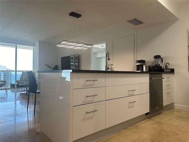 kitchen featuring dark countertops, white cabinets, and hanging light fixtures