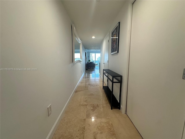 hallway featuring baseboards and recessed lighting