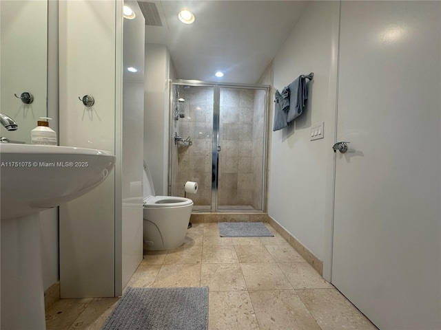 full bathroom with toilet, a stall shower, baseboards, and recessed lighting