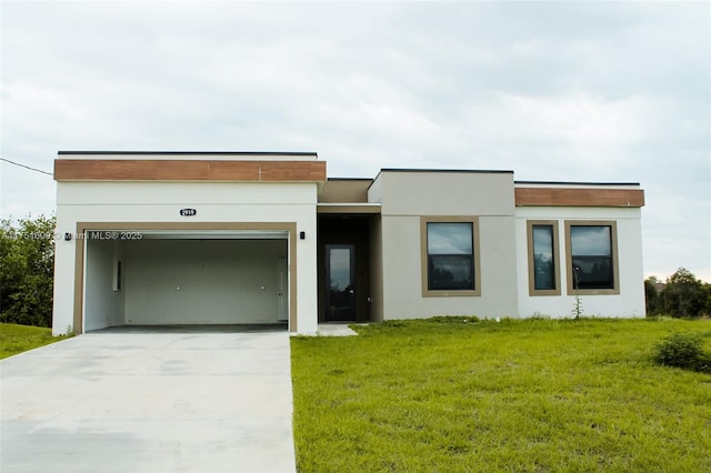 view of front of house featuring a garage, a front yard, driveway, and stucco siding