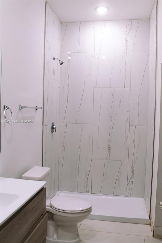 bathroom with toilet, a stall shower, and vanity