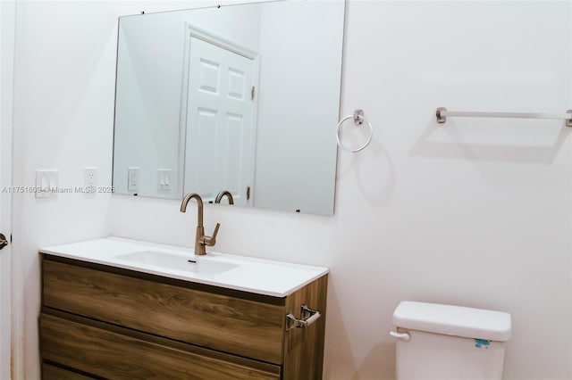 half bathroom featuring vanity and toilet