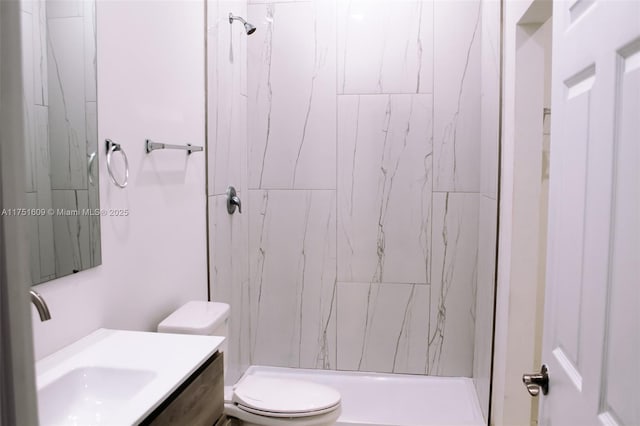 bathroom featuring toilet, a shower stall, and vanity