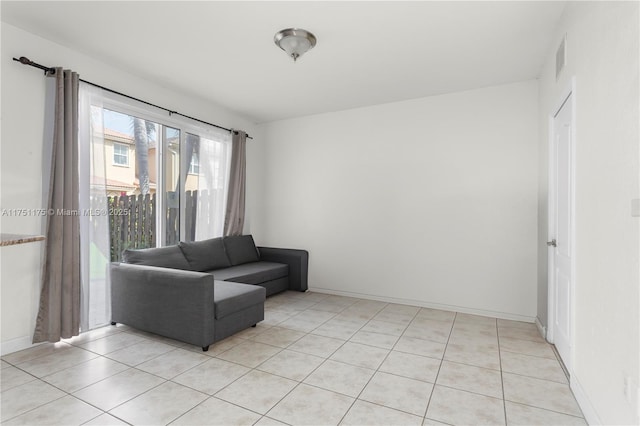 living area with light tile patterned floors, visible vents, and baseboards