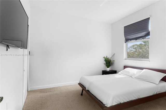 bedroom featuring light colored carpet and baseboards