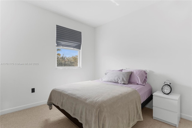 bedroom featuring baseboards and light colored carpet