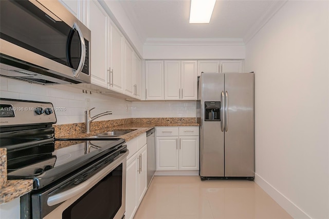 kitchen with a sink, white cabinetry, appliances with stainless steel finishes, decorative backsplash, and crown molding