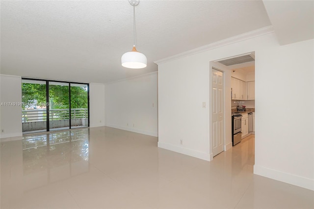 spare room with a textured ceiling, baseboards, and crown molding