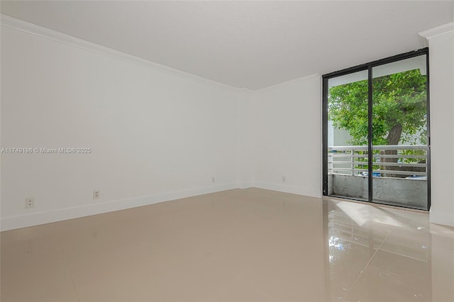 unfurnished room with crown molding, a wall of windows, and baseboards