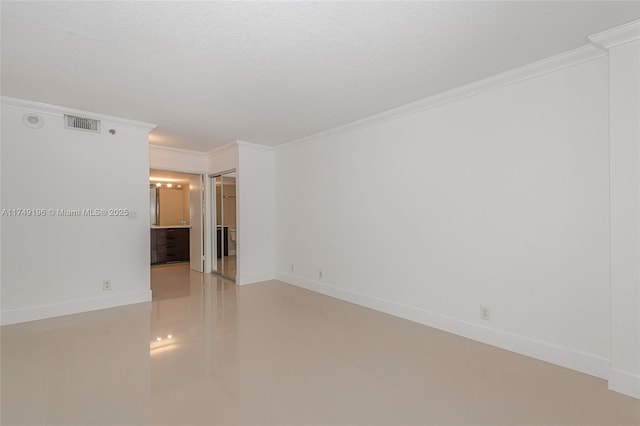 unfurnished room featuring baseboards, visible vents, ornamental molding, and a textured ceiling