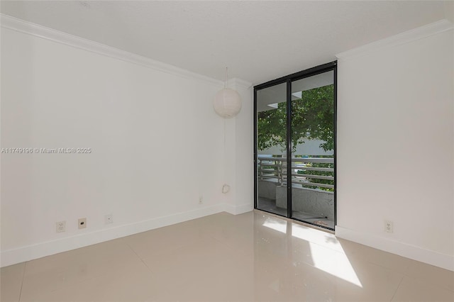 spare room featuring expansive windows, crown molding, baseboards, and tile patterned floors