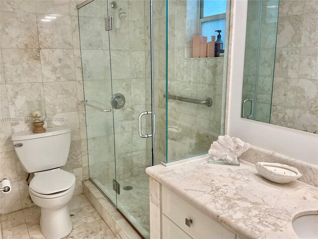 325 Ocean Dr Unit 308, Miami Beach, FL 33139 - full bathroom with a shower stall, toilet, vanity, and tile walls