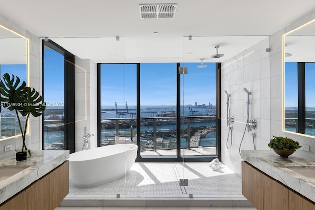 bathroom featuring a walk in shower, expansive windows, vanity, and visible vents