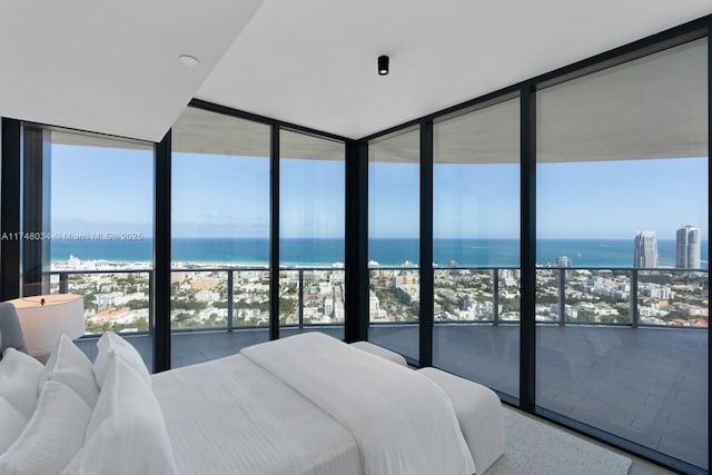 bedroom featuring expansive windows, multiple windows, and a water view