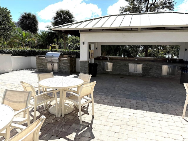 view of patio / terrace featuring exterior kitchen, outdoor dining area, a gazebo, and area for grilling