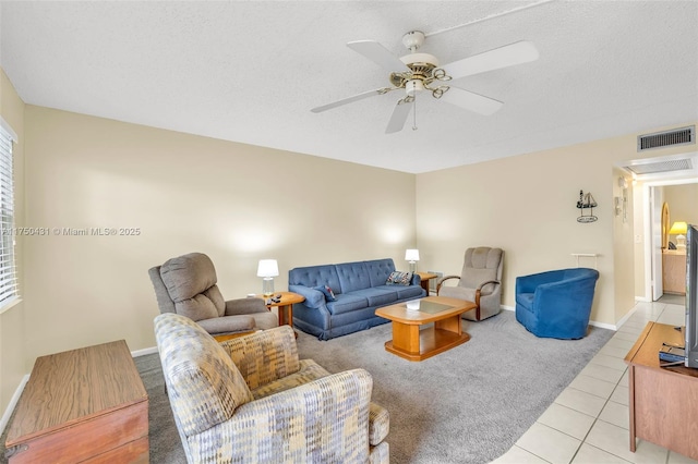 living room with baseboards, tile patterned floors, carpet flooring, visible vents, and ceiling fan