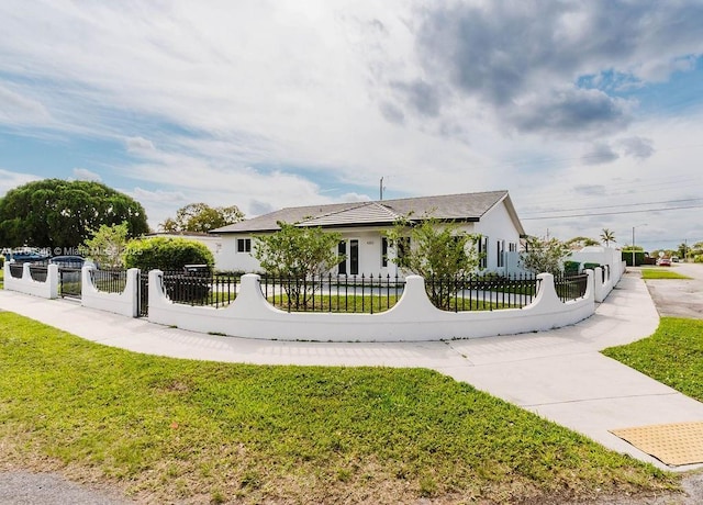 exterior space featuring a fenced front yard and a lawn