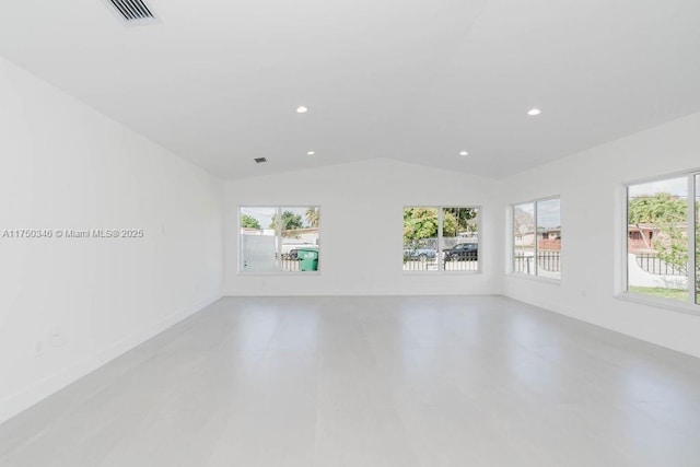 empty room with lofted ceiling, visible vents, baseboards, and recessed lighting