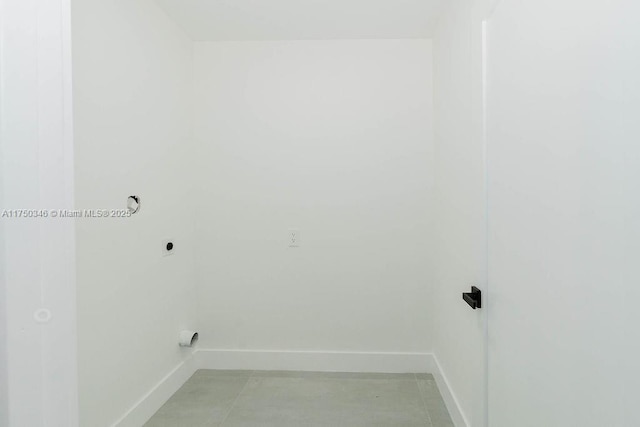 laundry area with laundry area, hookup for an electric dryer, baseboards, and light tile patterned flooring