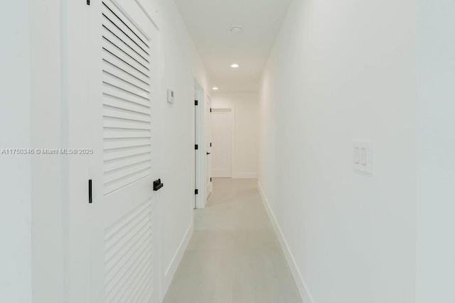 hall featuring baseboards and recessed lighting