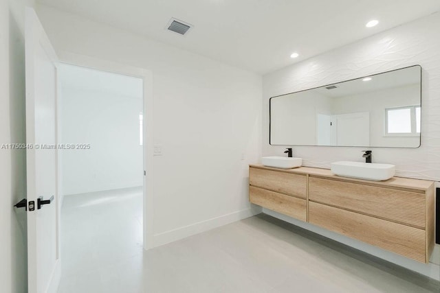bathroom featuring double vanity, visible vents, a sink, and recessed lighting
