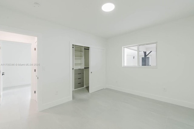 unfurnished bedroom featuring baseboards and a closet