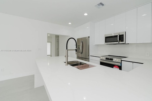 kitchen with recessed lighting, white cabinets, light countertops, appliances with stainless steel finishes, and modern cabinets