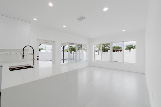 unfurnished room featuring a sink, visible vents, and recessed lighting