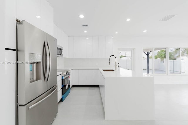 kitchen with white cabinets, modern cabinets, stainless steel appliances, and a sink