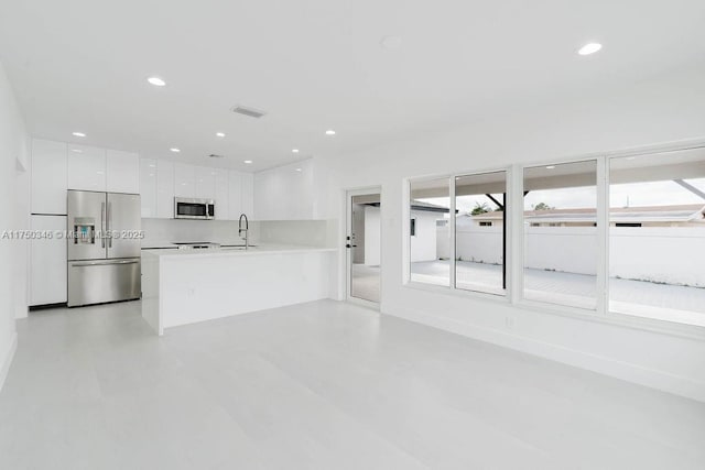 kitchen featuring recessed lighting, stainless steel appliances, white cabinetry, light countertops, and modern cabinets